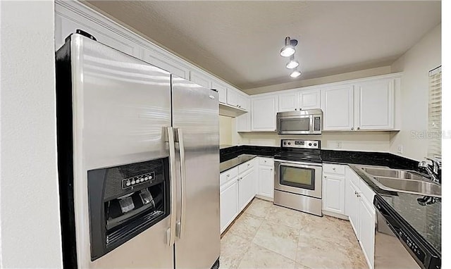 kitchen with stainless steel appliances, white cabinetry, and sink