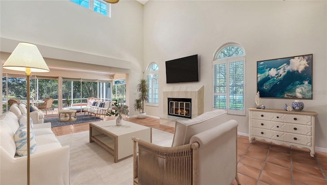 living room featuring a high ceiling, a wealth of natural light, and a premium fireplace