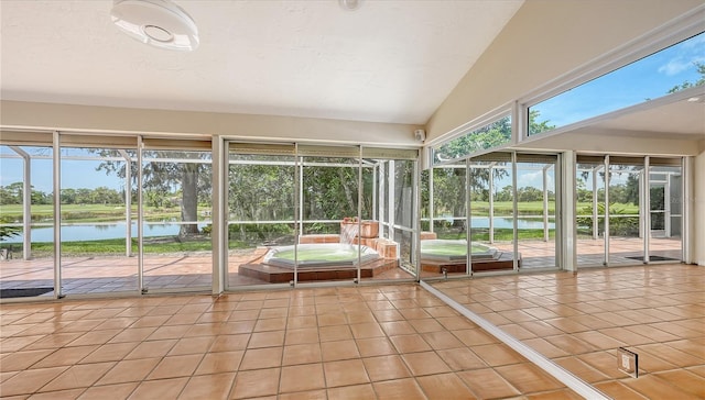 unfurnished sunroom featuring a water view and vaulted ceiling