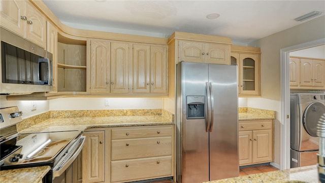 kitchen featuring light stone countertops, stainless steel appliances, and light brown cabinetry