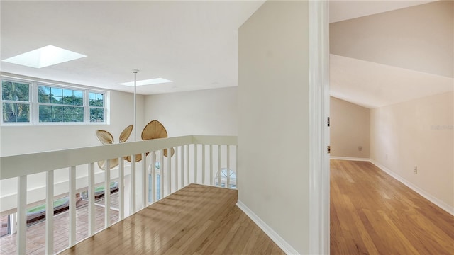 hallway with a skylight and light wood-type flooring