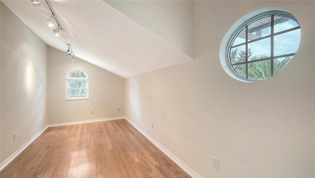 additional living space featuring light hardwood / wood-style floors and lofted ceiling