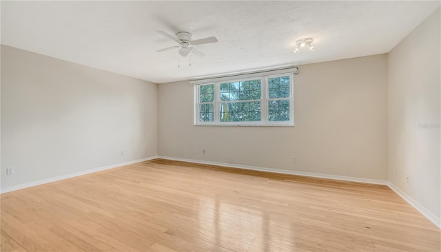 empty room with ceiling fan and light hardwood / wood-style floors