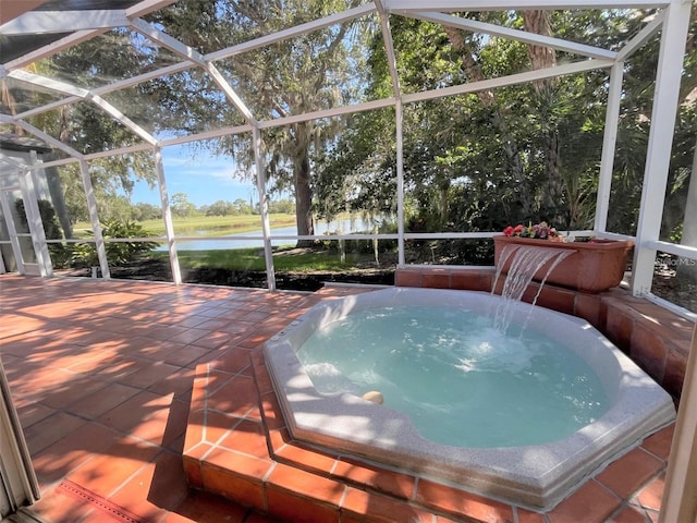 exterior space with pool water feature, glass enclosure, a water view, and a patio