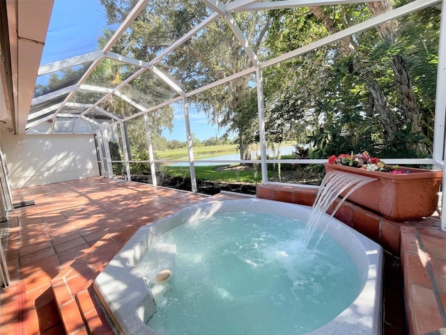 view of swimming pool featuring glass enclosure, a water view, pool water feature, a patio, and a hot tub