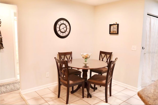 dining space with light tile patterned floors and baseboards