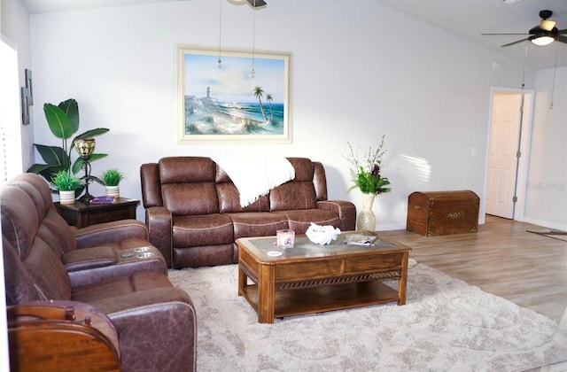 living area featuring a ceiling fan, vaulted ceiling, baseboards, and wood finished floors