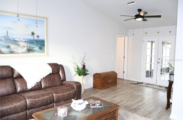 living area with french doors, visible vents, a ceiling fan, vaulted ceiling, and wood finished floors