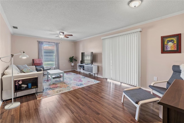 living room with hardwood / wood-style floors, a textured ceiling, ceiling fan, and ornamental molding