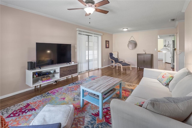 living room featuring ceiling fan, hardwood / wood-style floors, a textured ceiling, and ornamental molding