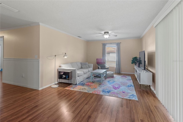 living room featuring hardwood / wood-style floors, a textured ceiling, and ornamental molding