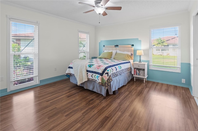 bedroom featuring multiple windows, ceiling fan, dark hardwood / wood-style flooring, and ornamental molding