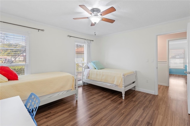 bedroom with multiple windows, ceiling fan, dark wood-type flooring, and ornamental molding