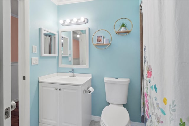 bathroom featuring vanity, toilet, curtained shower, and ornamental molding