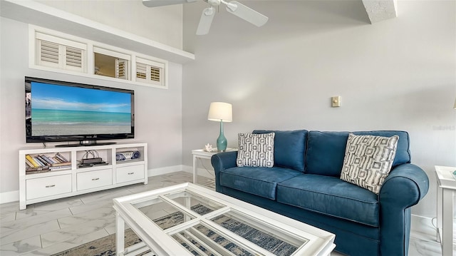 living room featuring ceiling fan and a towering ceiling