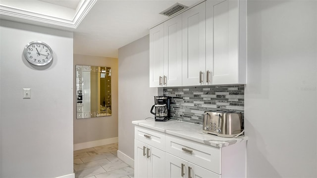 bar with white cabinets, light stone counters, and tasteful backsplash