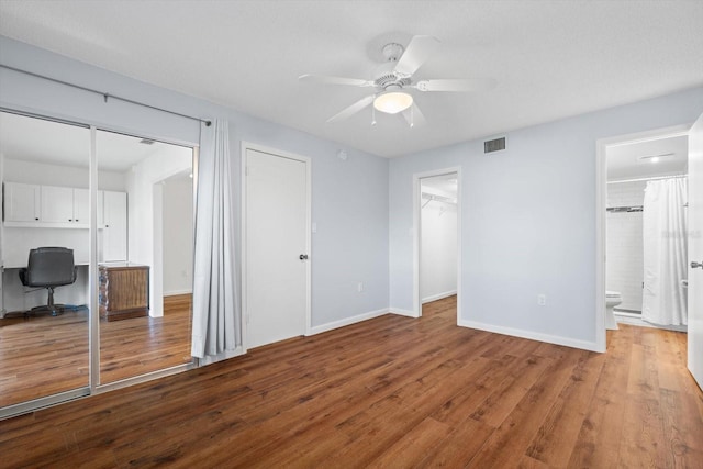 unfurnished bedroom with connected bathroom, ceiling fan, and light hardwood / wood-style flooring