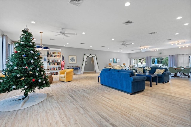 living room featuring ceiling fan and light hardwood / wood-style floors