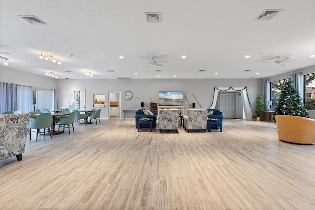 unfurnished living room featuring light wood-type flooring, plenty of natural light, and ceiling fan