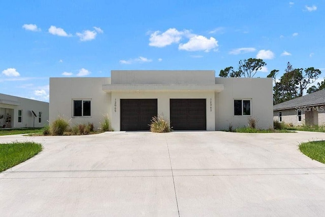 pueblo revival-style home featuring a garage