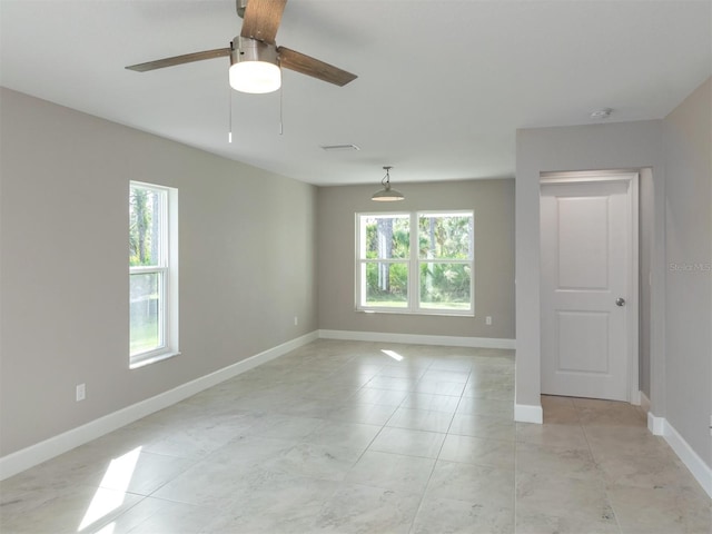 empty room featuring a wealth of natural light and ceiling fan