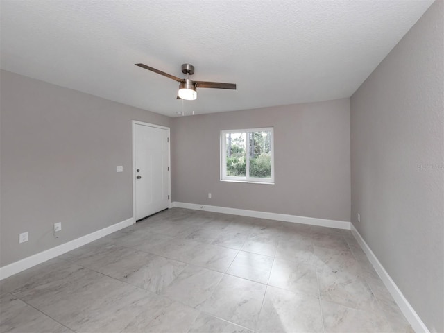 empty room with a textured ceiling and ceiling fan