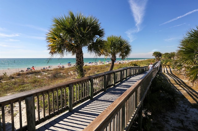 surrounding community featuring a water view and a beach view