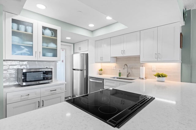 kitchen featuring white cabinetry, sink, appliances with stainless steel finishes, and tasteful backsplash