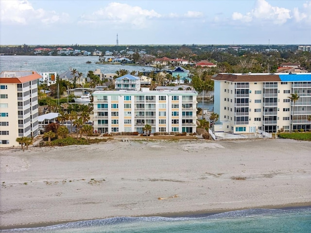 birds eye view of property with a water view and a beach view