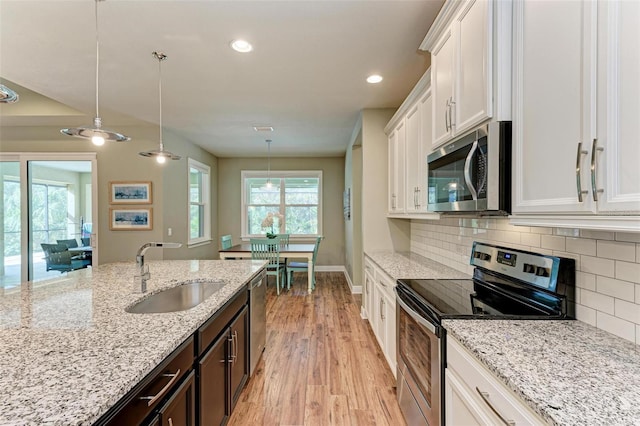 kitchen with sink, hanging light fixtures, stainless steel appliances, dark brown cabinets, and white cabinets