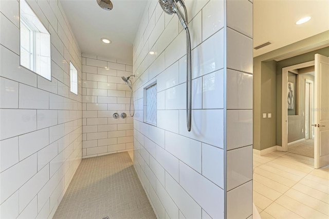 bathroom featuring tile patterned flooring and a tile shower