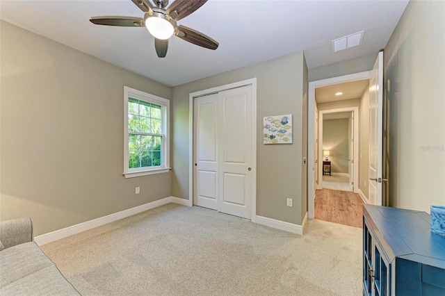 carpeted bedroom with a closet and ceiling fan