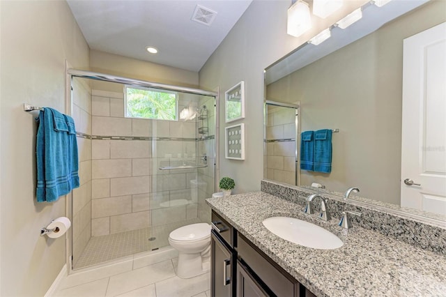 bathroom featuring tile patterned flooring, vanity, toilet, and an enclosed shower