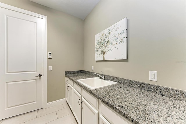 clothes washing area featuring light tile patterned floors and sink