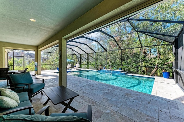 view of pool featuring glass enclosure and a patio