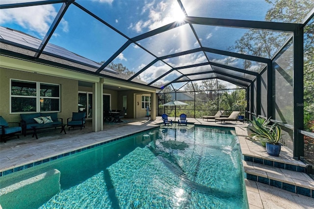 view of pool featuring pool water feature, glass enclosure, a patio area, and outdoor lounge area