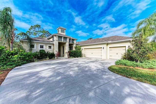 view of front of property with concrete driveway, an attached garage, and stucco siding