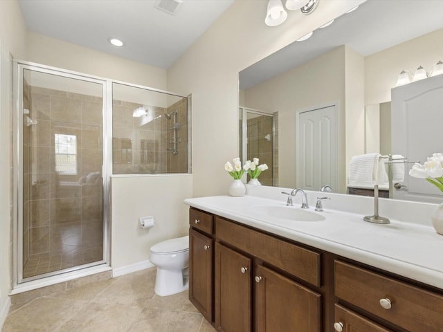 bathroom with tile patterned flooring, vanity, toilet, and a shower with shower door