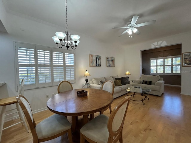 dining room featuring ceiling fan with notable chandelier, light hardwood / wood-style flooring, and a healthy amount of sunlight