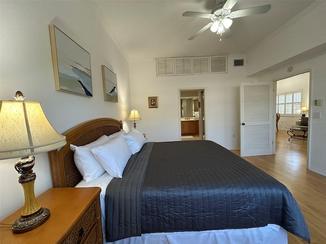 bedroom with connected bathroom, light hardwood / wood-style floors, ceiling fan, and crown molding