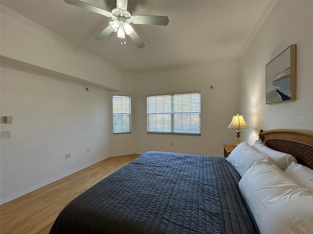 bedroom featuring ceiling fan, ornamental molding, and light wood-type flooring