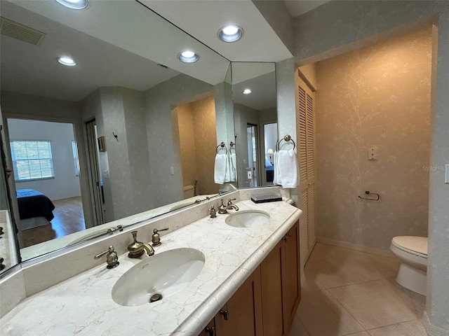 bathroom with tile patterned flooring, vanity, and toilet