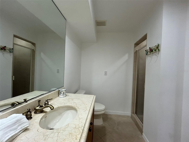 bathroom featuring toilet, vanity, tile patterned floors, and a shower with shower door