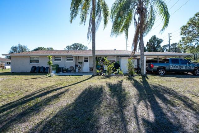 ranch-style home with a front lawn and a carport