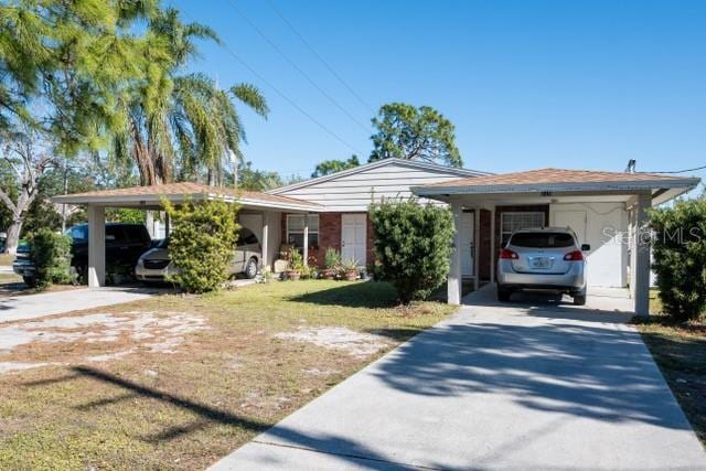 ranch-style house featuring a front yard and a carport