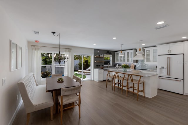 dining area featuring hardwood / wood-style floors and an inviting chandelier