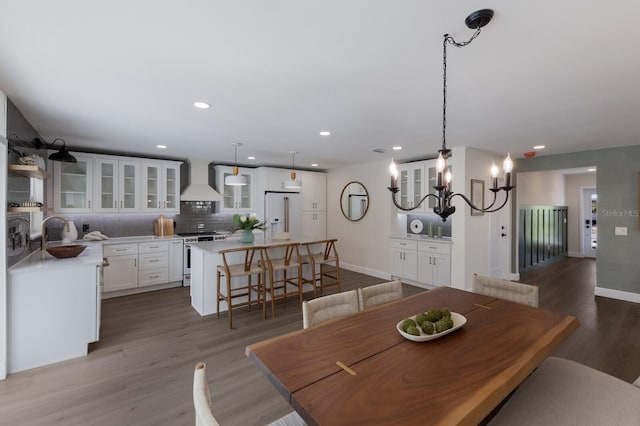 dining room featuring hardwood / wood-style floors, sink, and a chandelier