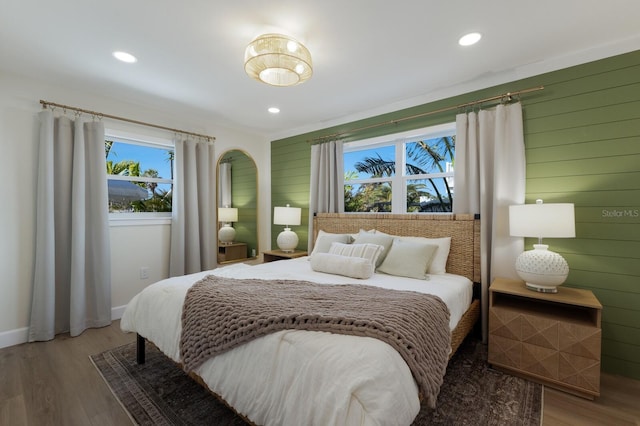 bedroom featuring wood-type flooring and wood walls