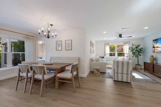 dining room featuring light hardwood / wood-style flooring and ceiling fan with notable chandelier