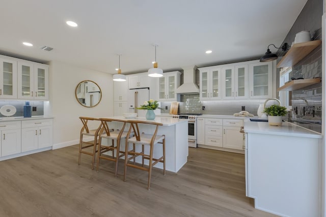 kitchen featuring white cabinetry, sink, decorative light fixtures, white appliances, and custom exhaust hood